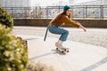 Skateboarding Woman In The City. Skater girl in denim is riding her board on the square. Athletic Woman skateboarder. Building on Royalty Free Stock Photo