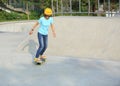 Skateboarding young woman riding on a skateboard