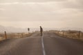 Skater on empty road with maks in Iceland. Great light in the ba