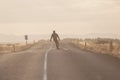Skater on empty road with maks in Iceland. Great light in the ba