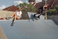 Skater Friends In Skatepark. Girl Sitting On Concrete Ramp, Guy Riding On Skateboard