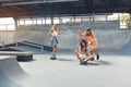 Skater Friends At Skatepark. Guy And Girls In Casual Outfit Riding On Skateboards