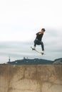 skater jumping high in the air with a snakeboard in a skatepark with white sky in the background. copyspace Royalty Free Stock Photo