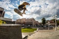 Skater make trick on street downhill near the stairs