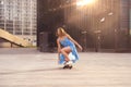 Skater woman in dress is training on longboard, doing a trick outdoor in a public park, sunrise in the morning industrial city vie Royalty Free Stock Photo