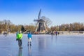 Skaters in front of the windmill at the frozen lake in Groningen Royalty Free Stock Photo