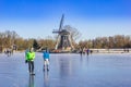 Skaters in front of the windmill at the frozen lake in Groningen