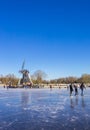 Skaters in front of the windmill at the frozen lake in Groningen Royalty Free Stock Photo