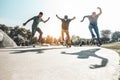 Skaters jumping with skateboard in city skate park - Young guys performing tricks and skills at sunset in suburb contest - Extreme