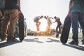 Skaters jumping with skateboard in city skate park - Young guys performing tricks and skills at sunset in suburb contest - Extreme