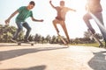 Skaters jumping with skateboard in city skate park - Young guys performing tricks and skills at sunset in suburb contest - Extreme