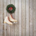 Skates hanging on the wooden planks wall with garland, winter Christmas background Royalty Free Stock Photo