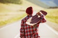 Man with skate is walking by road