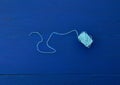 Skein of craft blue-white thread on a blue wooden background