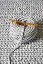 Skein of grey knitted yarn and a crochet hook