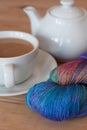 Skein or hank of indie yarn wool beside a cup of tea and teapot Royalty Free Stock Photo