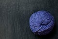 Skein of purple yarn with black slate background