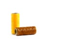 A skein of yellow and brown thread. Coils of colored threads on a white background. Waxed sewing thread for leather