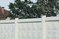 Skeins of gray iron barbed wire on a white concrete wall