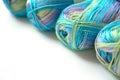 Skeins of multi-colored gradient yarn for knitting children`s clothes on white background. Gentle multicolor yarn of blue, green,