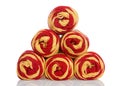 Skeins of red and gold yarn stacked pyramid shape isolated on white Royalty Free Stock Photo