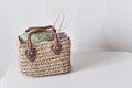 Skeins of yarn and wooden circular knitting needles in handmade straw basket on white table. Royalty Free Stock Photo