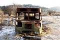 skeleton of abandoned old bus against winter hills