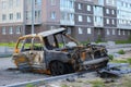 The skeleton of a burnt-out passenger car on the street