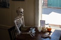 skeleton is drinking a coffee with a cup full of disgusting cockroaches