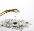 Skeleton fingers holding sand-glass placed on dollars. concept of time - money and death. Royalty Free Stock Photo