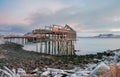 The skeleton of a fishing shed on the beach. Abandoned house against the Arctic sky. Old authentic village of Teriberka