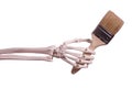 Skeleton hand holding paint brush