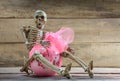 Skeleton hug gift on wood background. Royalty Free Stock Photo