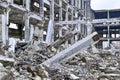 The skeleton of a large building of concrete beams, the foreground sticking out from under the wreckage a big pile