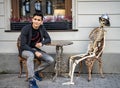 Skeleton and man behind coffee table at street