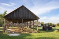 The skeleton of an old, destroyed barn being demolished on a sunny day. Grass