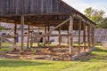 The skeleton of an old, destroyed barn being demolished on a sunny day. Grass