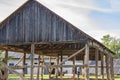 The skeleton of an old, destroyed barn being demolished on a sunny day. Grass