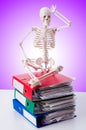 Skeleton with pile of files against gradient Royalty Free Stock Photo