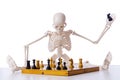 The skeleton playing chess game on white Royalty Free Stock Photo