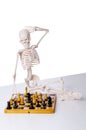 The skeleton playing chess game on white Royalty Free Stock Photo