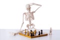 The skeleton playing chess game on white Royalty Free Stock Photo