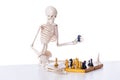 The skeleton playing chess game on white Royalty Free Stock Photo