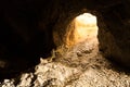 Skeleton scrambles to safety of a mine entrance crawling on rocks