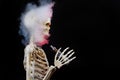 Skeleton vaping clouds of red highlighted vapor with an ecigarette Royalty Free Stock Photo