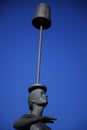 Woman balancing lamp on her head as a statue