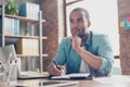 Skeptic, unsure, uncertain, doubts concept. Young african student is making decision sitting at the office in casual smart Royalty Free Stock Photo