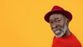 Skeptical black senior man with a questioning expression, wearing a red sweater and hat Royalty Free Stock Photo