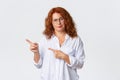 Skeptical and disappointed redhead middle-aged mother, woman in glasses scolding person, pointing fingers left at