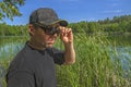 Skeptical look. Man in cap watches from under sunglasses with contempt, doubtful and scepticism outdoors Royalty Free Stock Photo